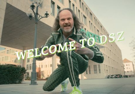 Ausstattung und Requisite Werbung "Datev", Mann mit grünem Jogginganzug am Eingang zum Firmengebäude