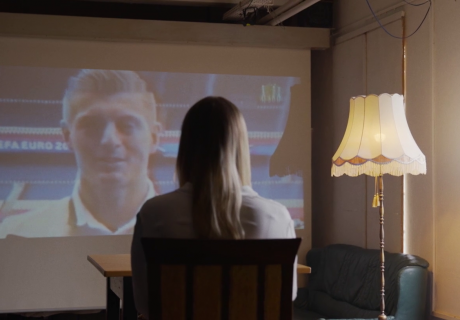 Frau schaut Sportübertragung auf Leinwand an