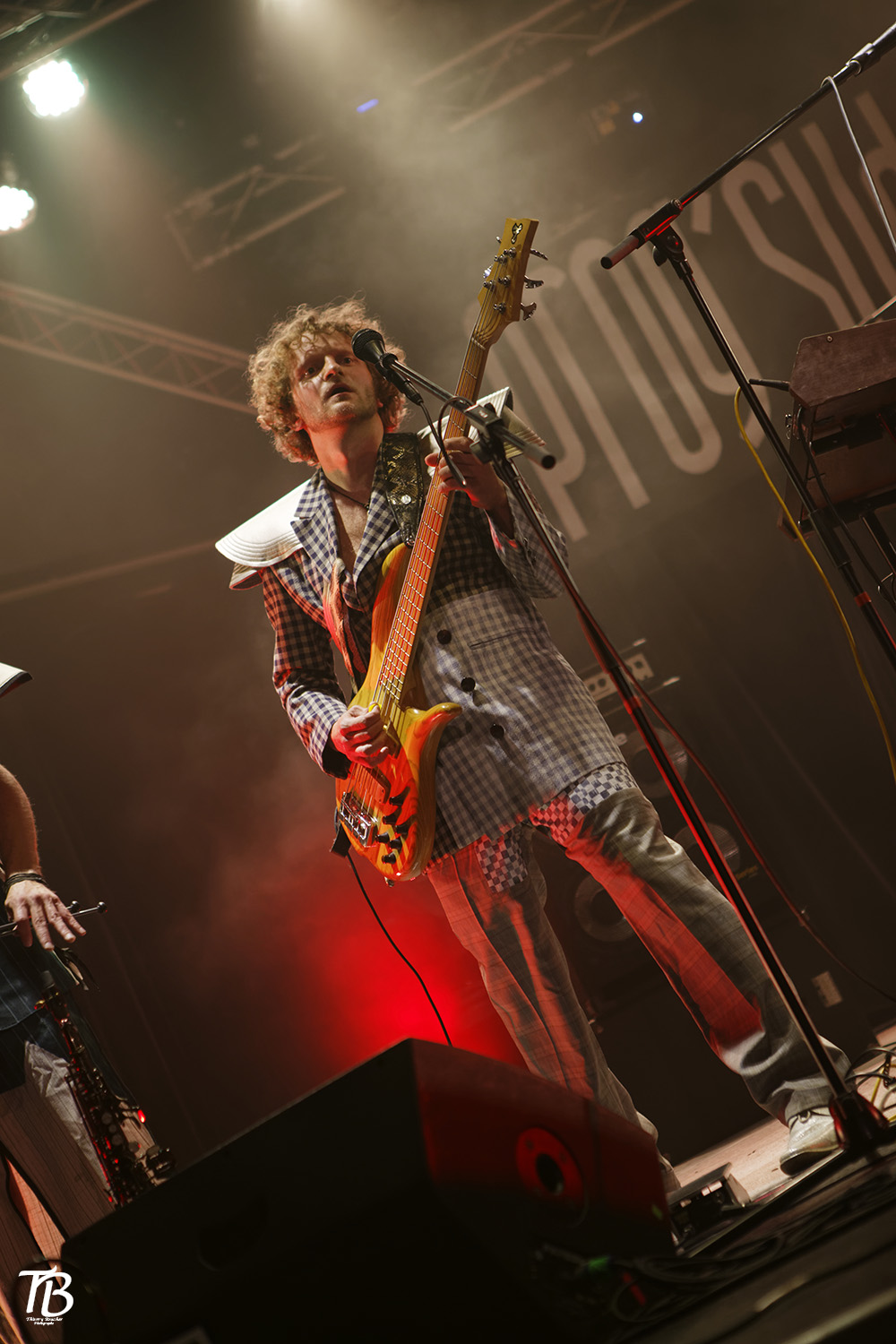 Kostümbild Konzert – Konzertkostüme „Knights“, Gitarrist in kariertem Anzug mit Rüstungselementen aus Stoff