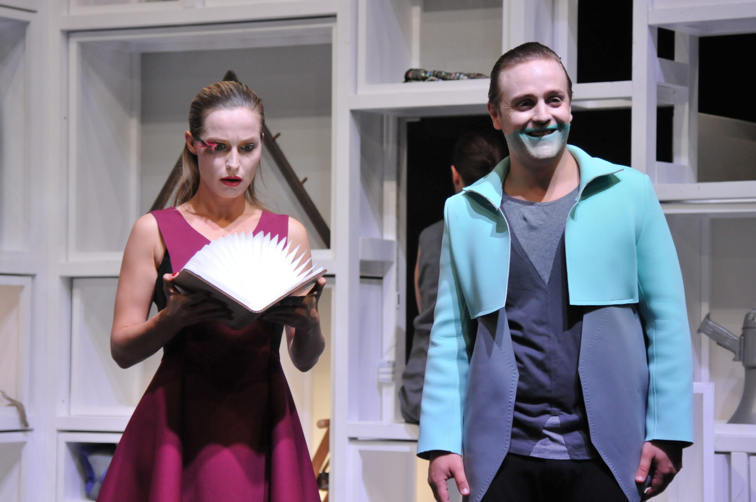 Bühnenbild und Kostümbild Theater – Theaterstück „Doctor Faustus Lights The Lights“, junge Frau blickt in leuchtendes Buch