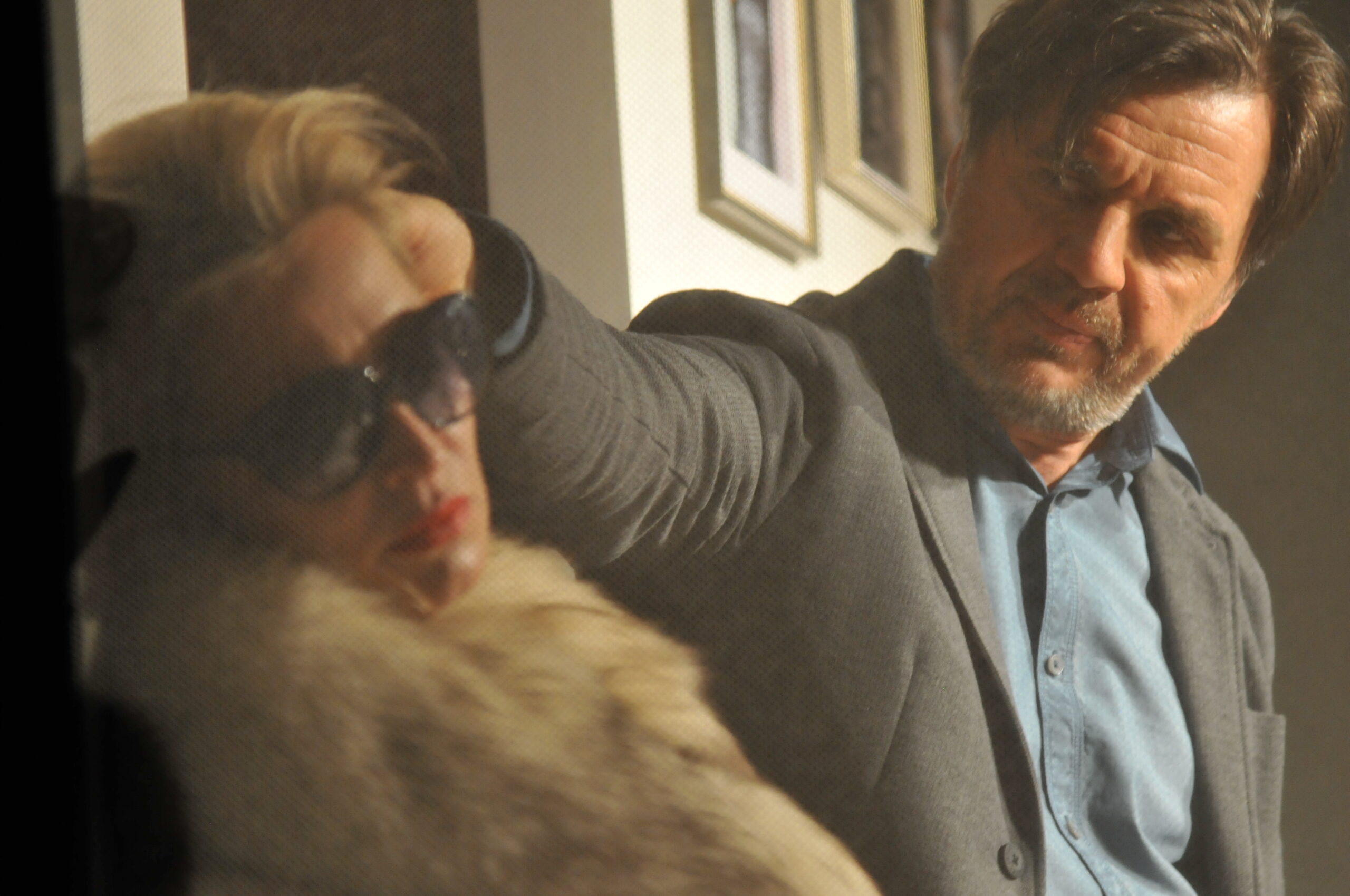 Frau in Pelzmantel und mit Sonnenbrille, dahinter ein Mann