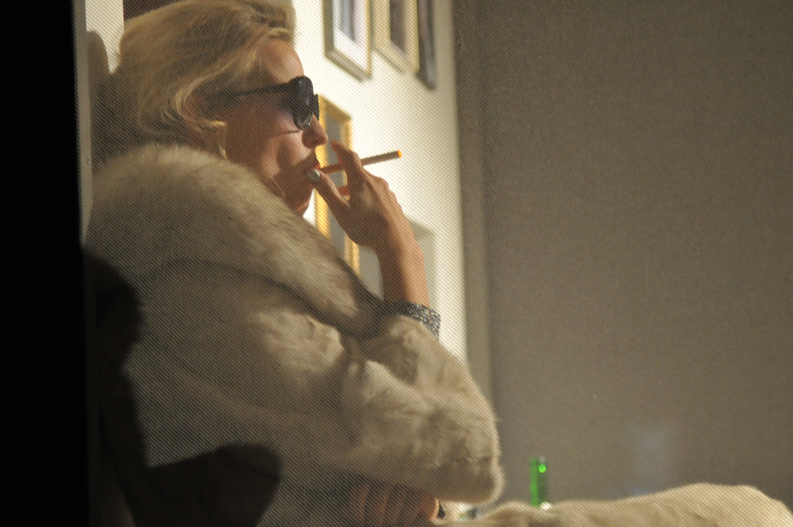 Bühnenbild und Kostümbild Theater – Theaterstück „Das Interview", Frau mit Pelzmantel und Sonnenbrille raucht