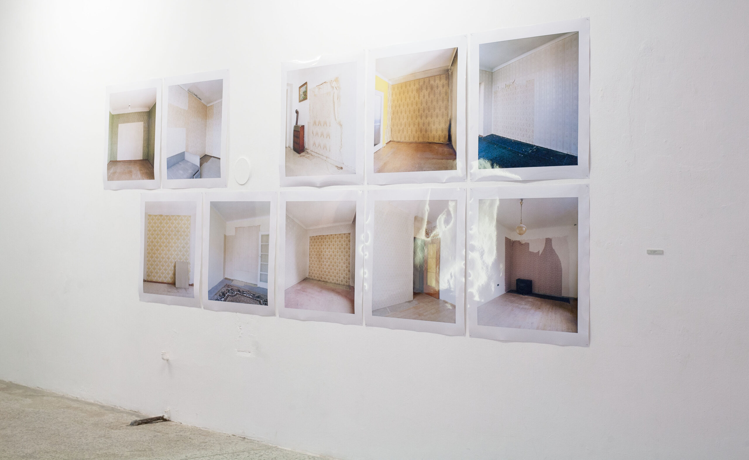 Zehn Bilder an der Wand, die Aufnahmen von verlassenen Räumen zeigen