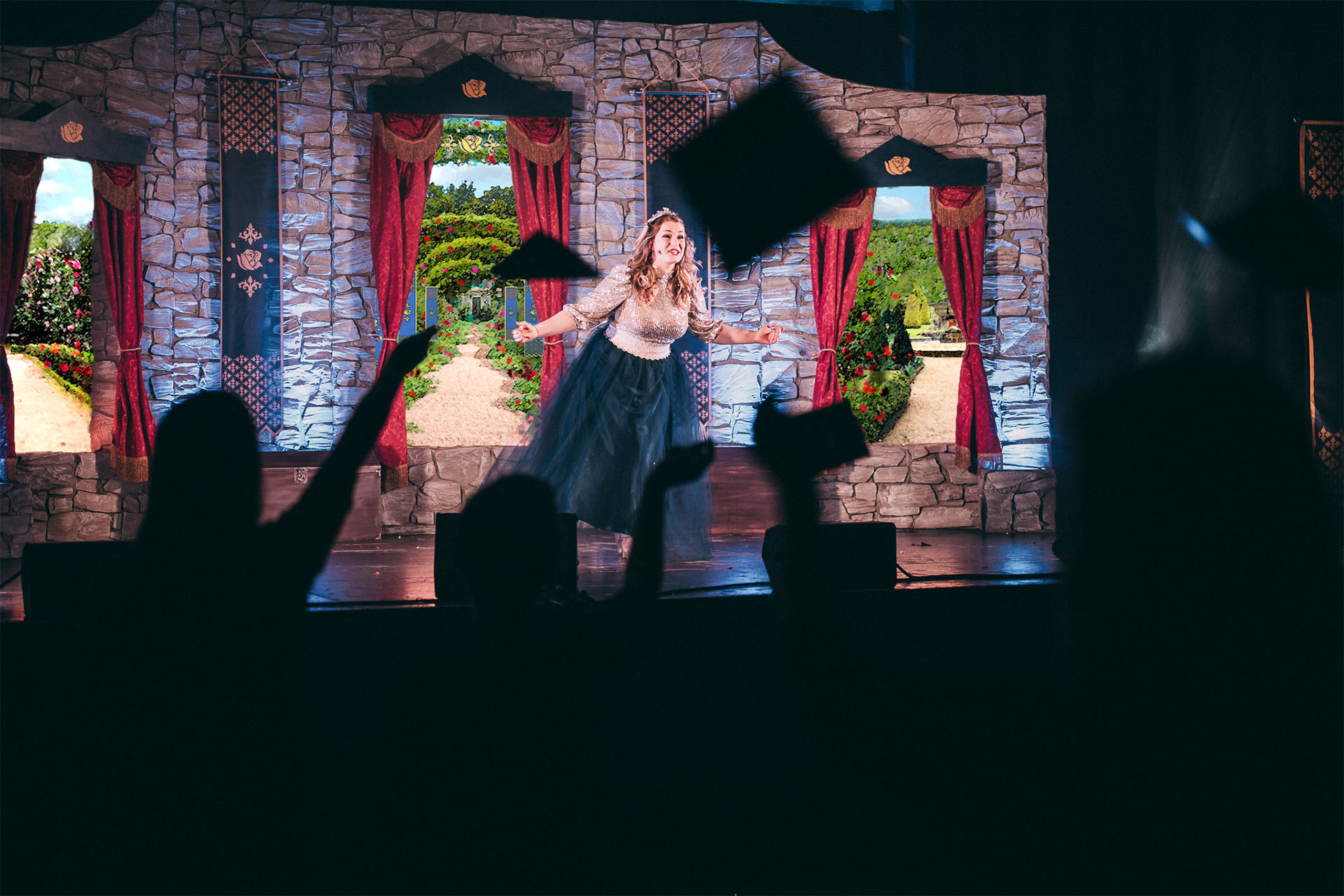 Eine Prinzessin singt während man Schatten vom jubelnden Publikum sieht