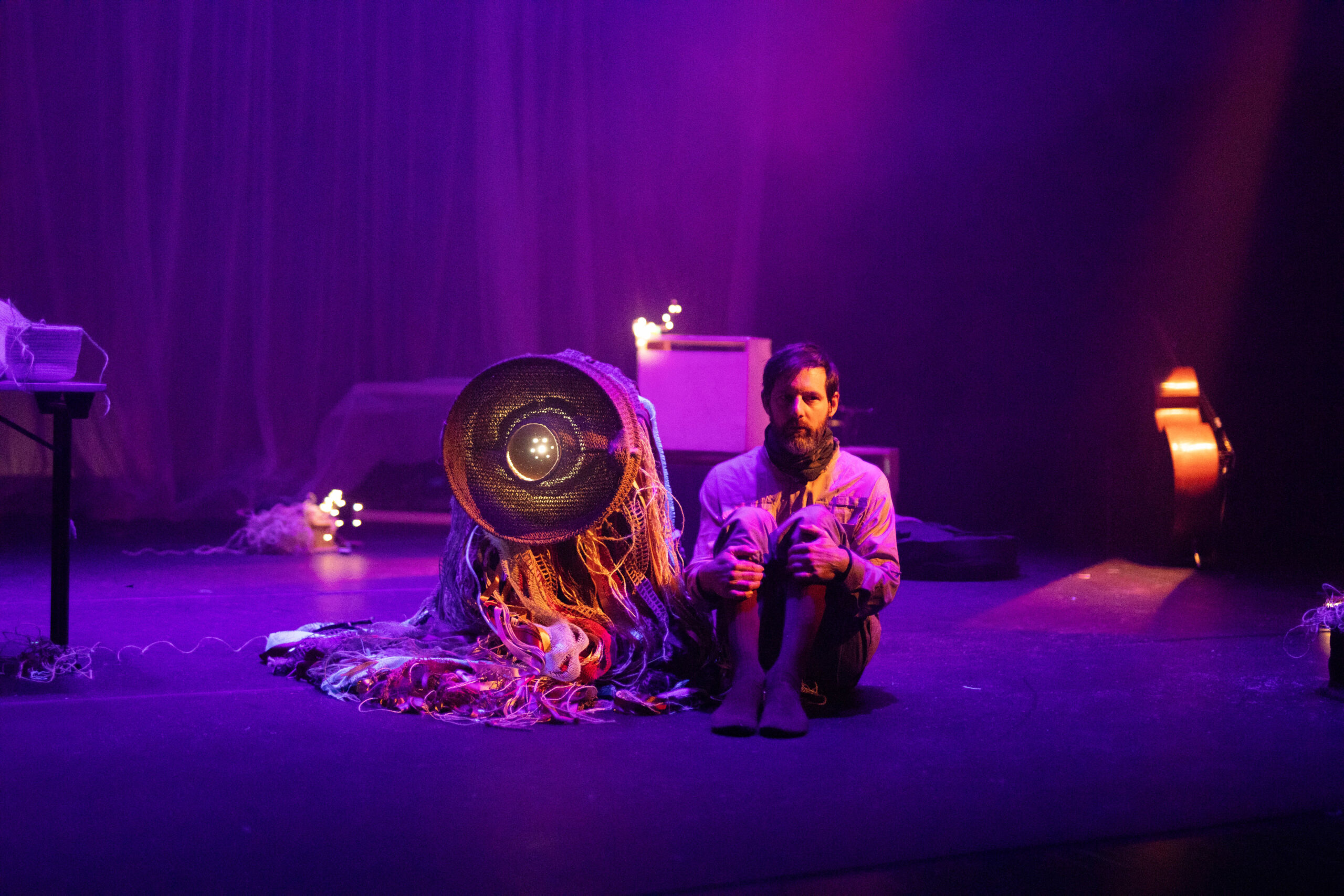 Bühnenbild und Kostümbild Theater – Tanztheater „The Collapse“, ein seltsames Wesen neben einem Mann mit angezogenen Knien