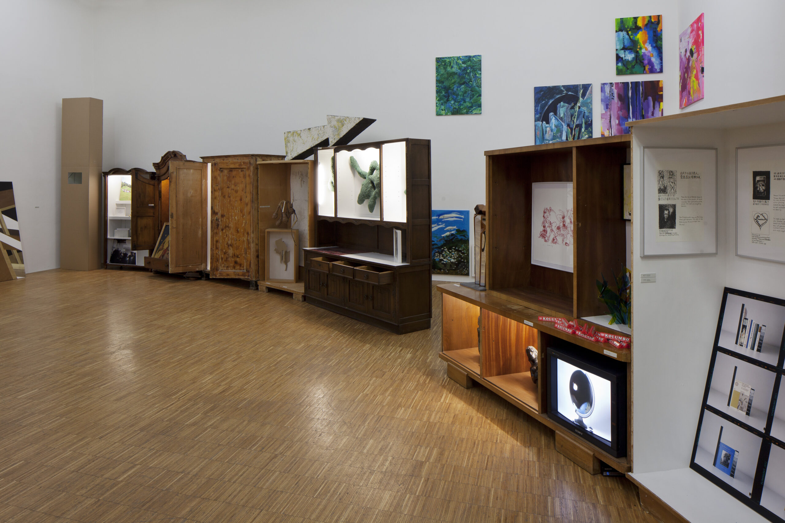 Ausstellungsgestaltung Raumdesign – Design Jahresausstellung „Für die Fülle“, ein Ausstellungsraum wie eine Wunderkammer: alte Schränke, in denen sich verschiedene Kunstwerke befinden